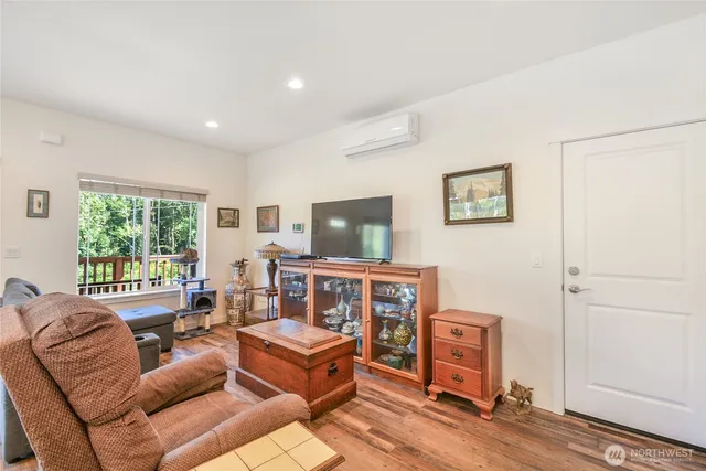 a living room with furniture a flat screen tv and a window