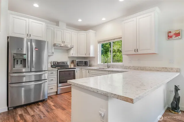 a kitchen with granite countertop a sink stainless steel appliances and cabinets