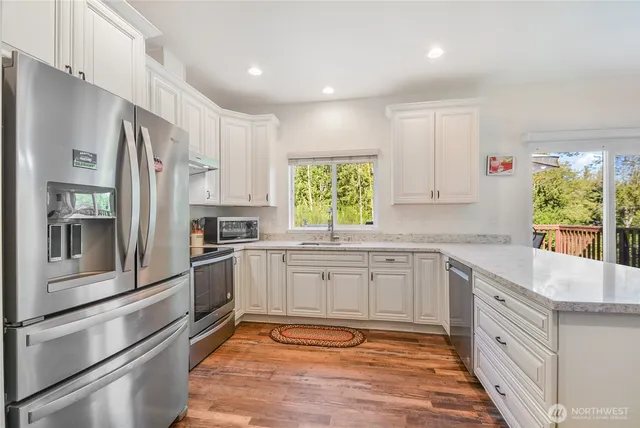 a kitchen with stainless steel appliances granite countertop a refrigerator and a stove top oven