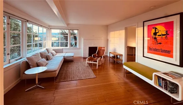 a living room with furniture and a large window with rug floor