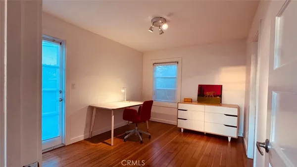 a view of a workspace with furniture and wooden floor