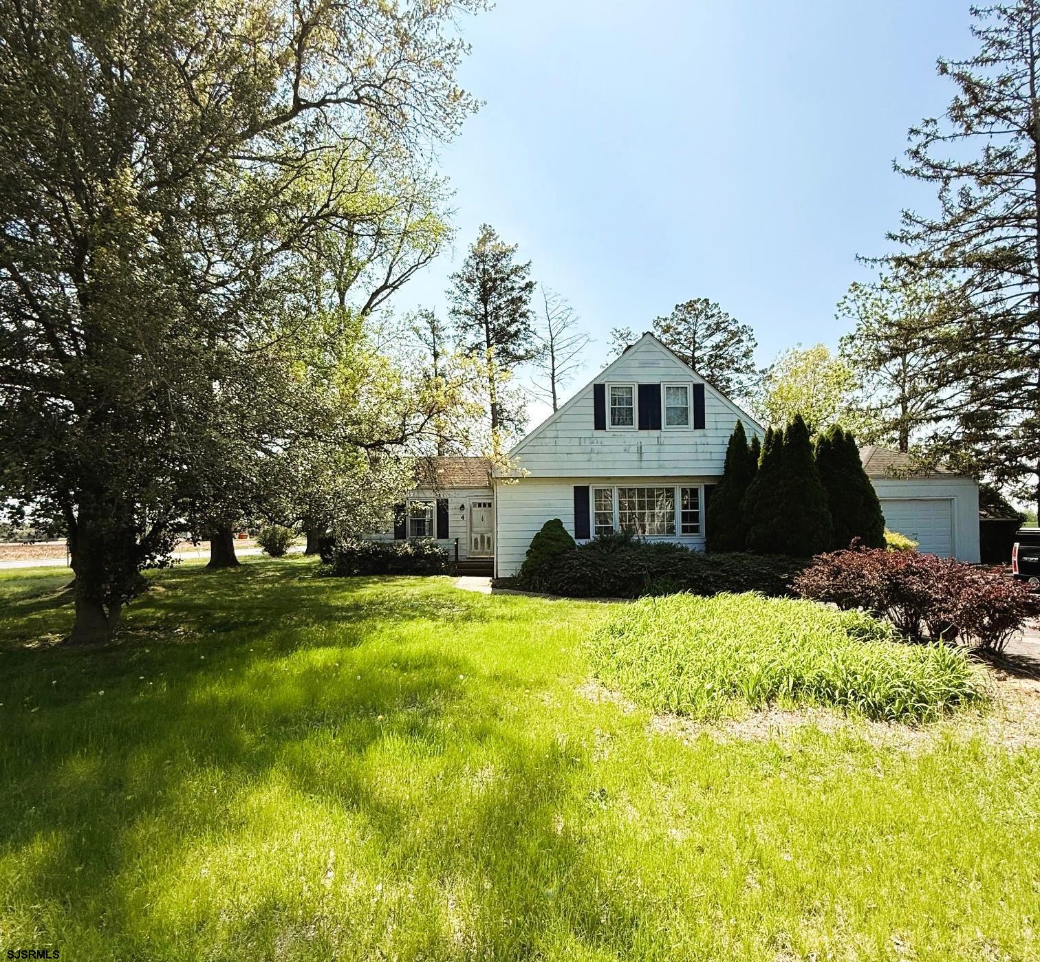 a view of a house with a big yard and large trees
