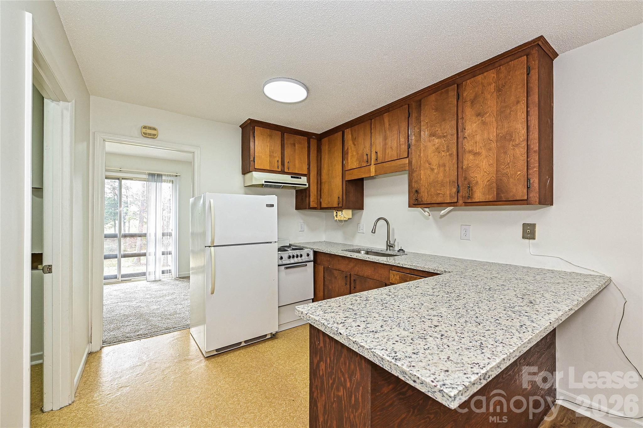 220 McDade Road, Unit 3 Forest City, NC 28043 - Photo 7 of 16 a kitchen with a stove a sink and a refrigerator