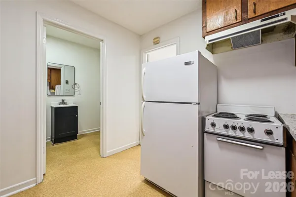a white refrigerator freezer and a stove sitting inside of a kitchen