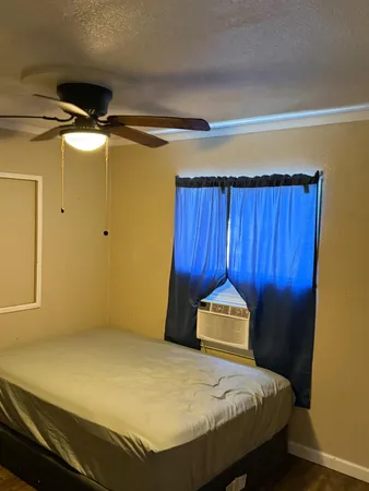 a bed sitting in a spacious bedroom next to a window