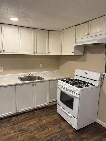 a white stove top oven sitting inside of a kitchen