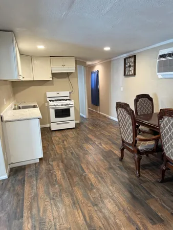a kitchen with a table chairs a stove and a refrigerator