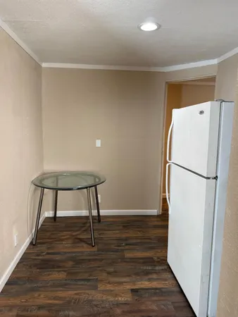a view of a kitchen with wooden floor and a refrigerator