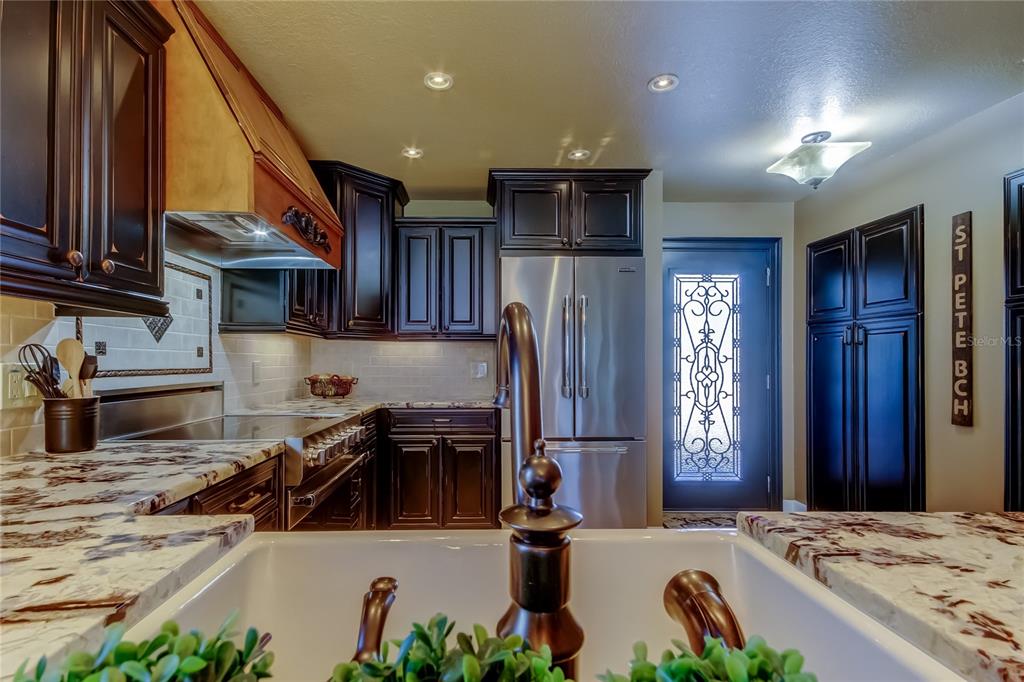 7003 Sunset Way, Unit 1 St. Pete Beach, FL 33706 - Photo 12 of 70 a kitchen with stainless steel appliances granite countertop a sink a stove and a refrigerator
