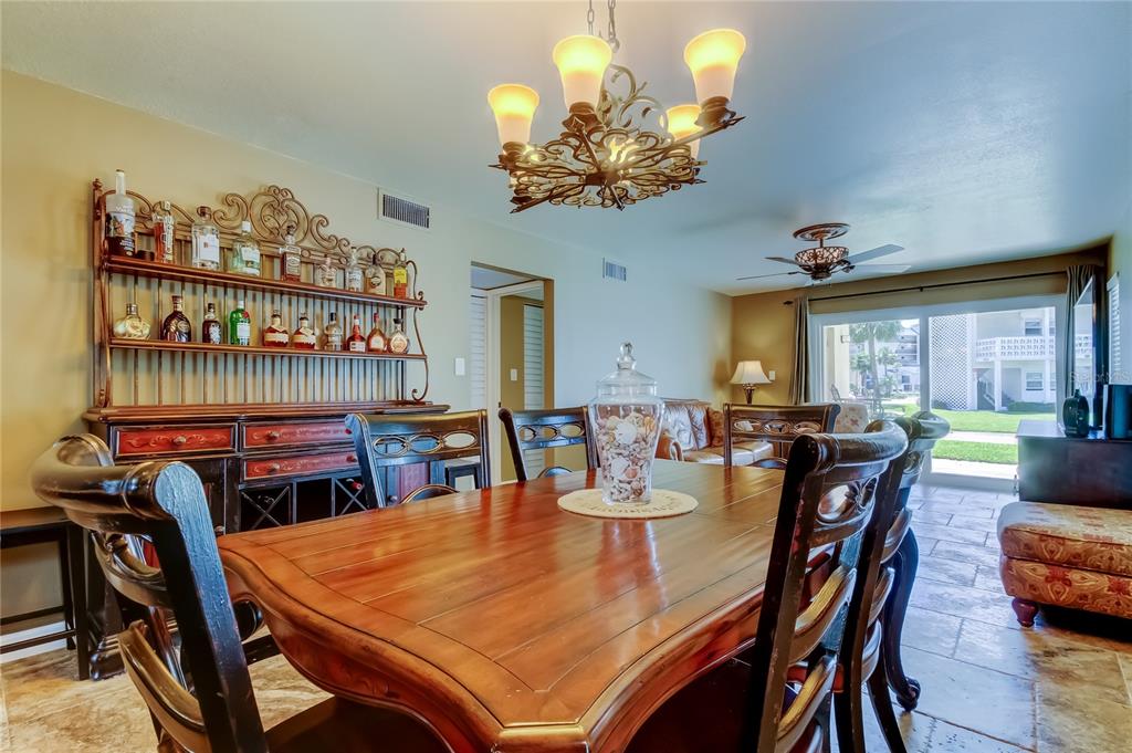 7003 Sunset Way, Unit 1 St. Pete Beach, FL 33706 - Photo 15 of 70 a view of a dining room with furniture and chandelier