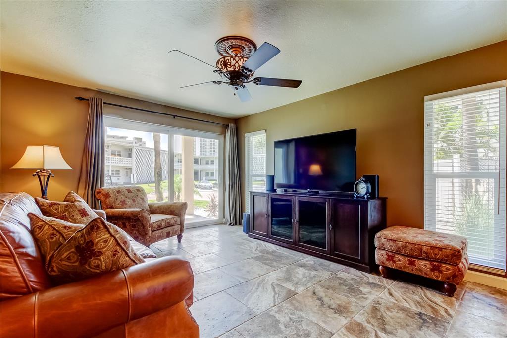 7003 Sunset Way, Unit 1 St. Pete Beach, FL 33706 - Photo 20 of 70 a living room with furniture a flat screen tv and a window