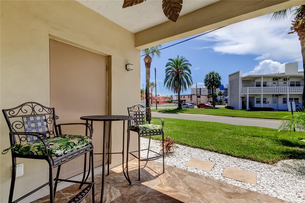7003 Sunset Way, Unit 1 St. Pete Beach, FL 33706 - Photo 26 of 70 a view of a chair and tables in the patio