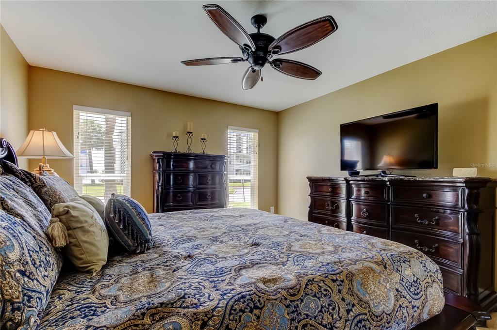 7003 Sunset Way, Unit 1 St. Pete Beach, FL 33706 - Photo 28 of 70 a bedroom with a bed and a flat screen tv