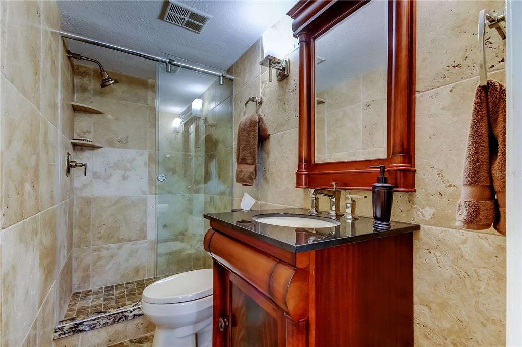 7003 Sunset Way, Unit 1 St. Pete Beach, FL 33706 - Photo 31 of 70 a bathroom with a sink a toilet and shower
