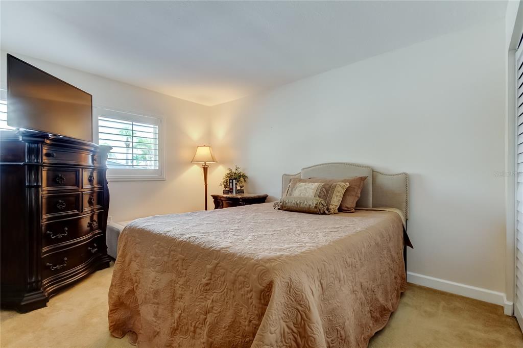 7003 Sunset Way, Unit 1 St. Pete Beach, FL 33706 - Photo 33 of 70 a bedroom with a bed and a flat screen tv