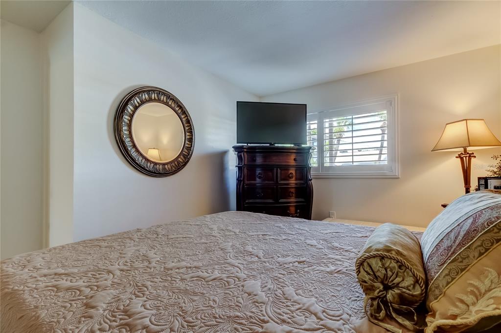 7003 Sunset Way, Unit 1 St. Pete Beach, FL 33706 - Photo 34 of 70 a bedroom with a bed and a flat screen tv