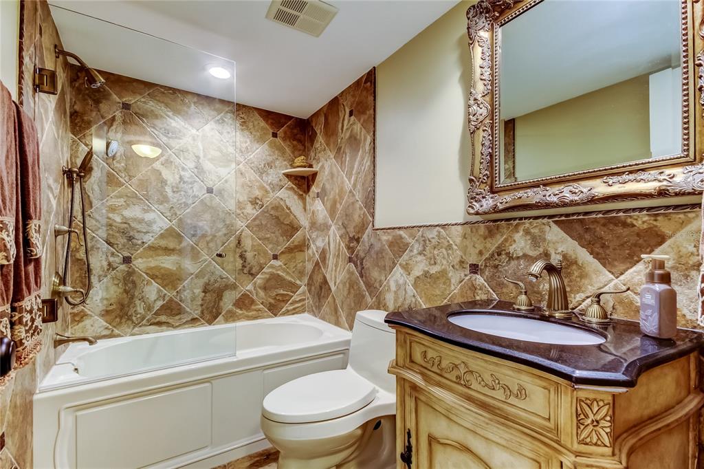 7003 Sunset Way, Unit 1 St. Pete Beach, FL 33706 - Photo 38 of 70 a bathroom with a toilet sink and mirror