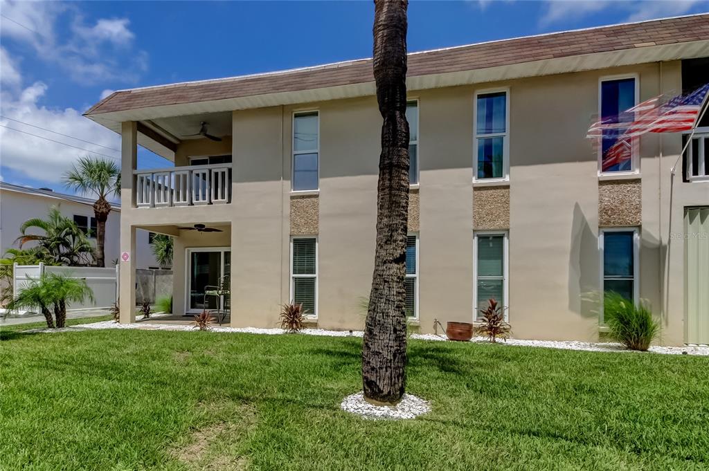 7003 Sunset Way, Unit 1 St. Pete Beach, FL 33706 - Photo 40 of 70 a front view of a house with a yard