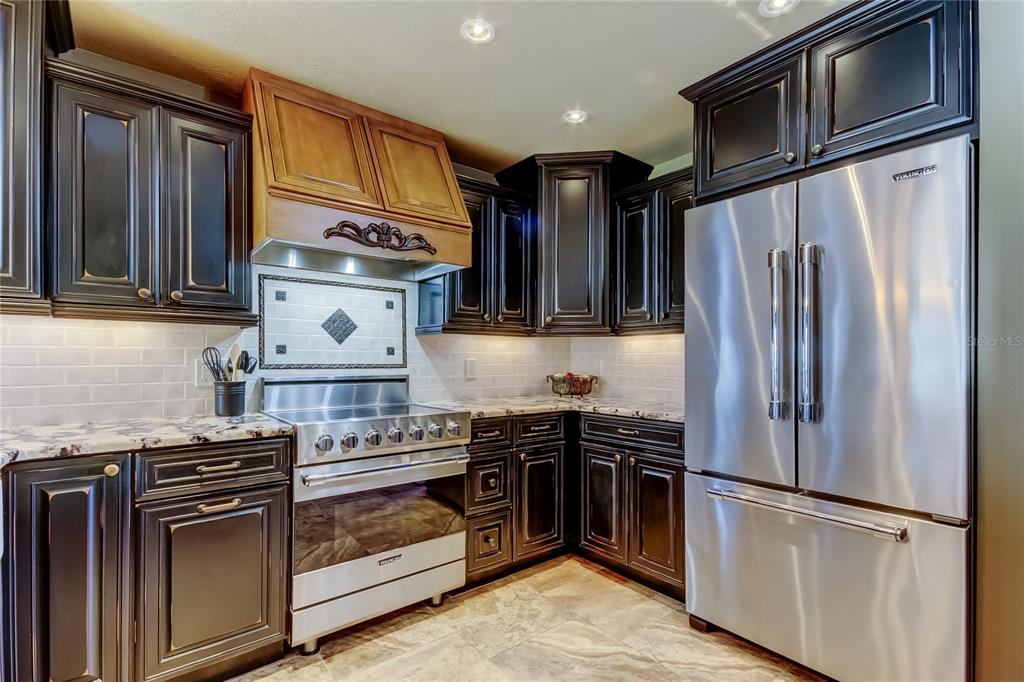 7003 Sunset Way, Unit 1 St. Pete Beach, FL 33706 - Photo 6 of 70 a kitchen with stainless steel appliances granite countertop a refrigerator stove and sink
