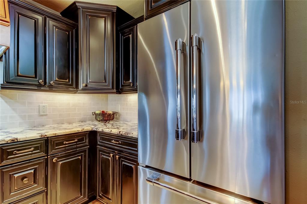 7003 Sunset Way, Unit 1 St. Pete Beach, FL 33706 - Photo 7 of 70 a kitchen with metallic refrigerator and cabinets