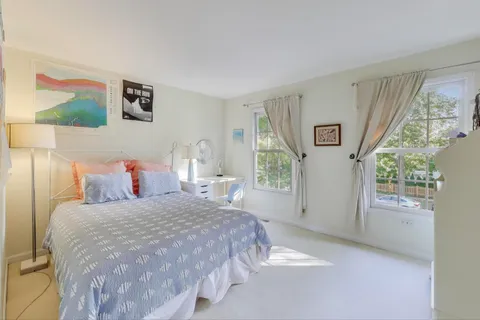 a bedroom with a bed and large windows