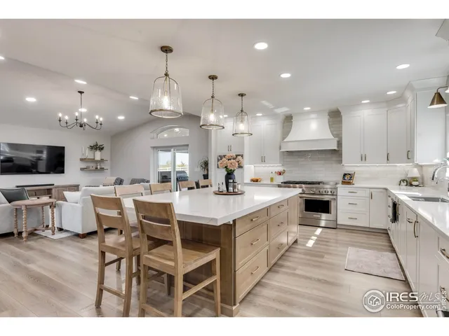 a large kitchen with kitchen island a sink table and chairs