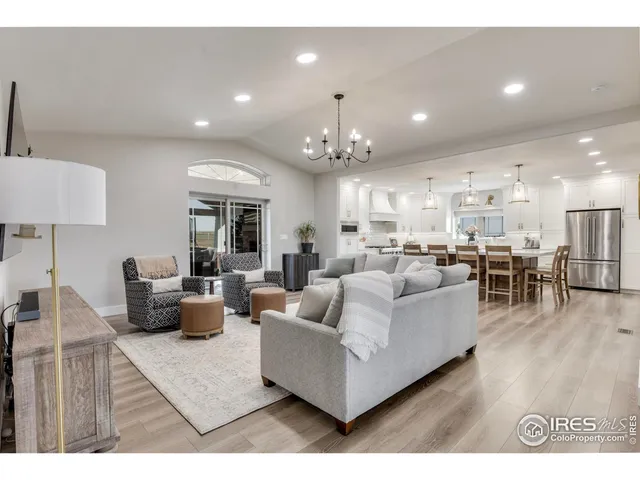 a living room with furniture kitchen view and a chandelier