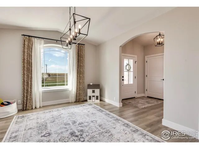 a view of a big room with a chandelier fan and windows