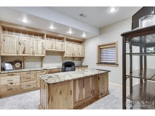a bathroom with a granite countertop sink a toilet a mirror and shower