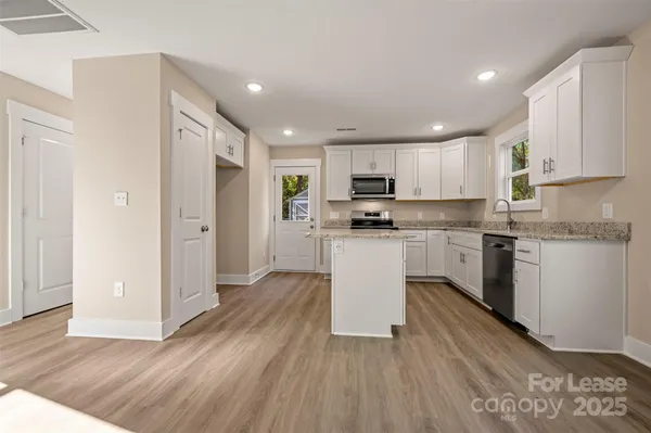 a kitchen with white cabinets and stainless steel appliances