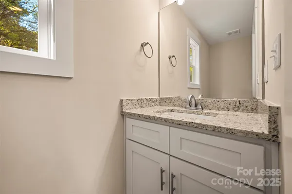 a bathroom with a granite countertop sink and a mirror