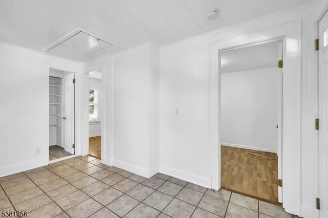 a view of empty room with wooden floor and window