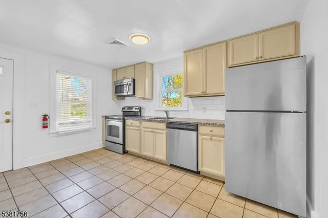a view of empty room with wooden floor and window