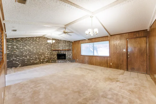 a view of empty room with fireplace and window