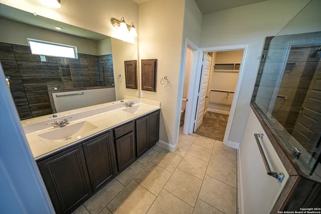 a bathroom with a sink a mirror and a shower