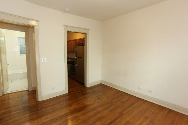 4716 North Racine Avenue, Unit 2E Chicago, IL 60640 - Photo 5 of 19 an empty room with wooden floor and closet