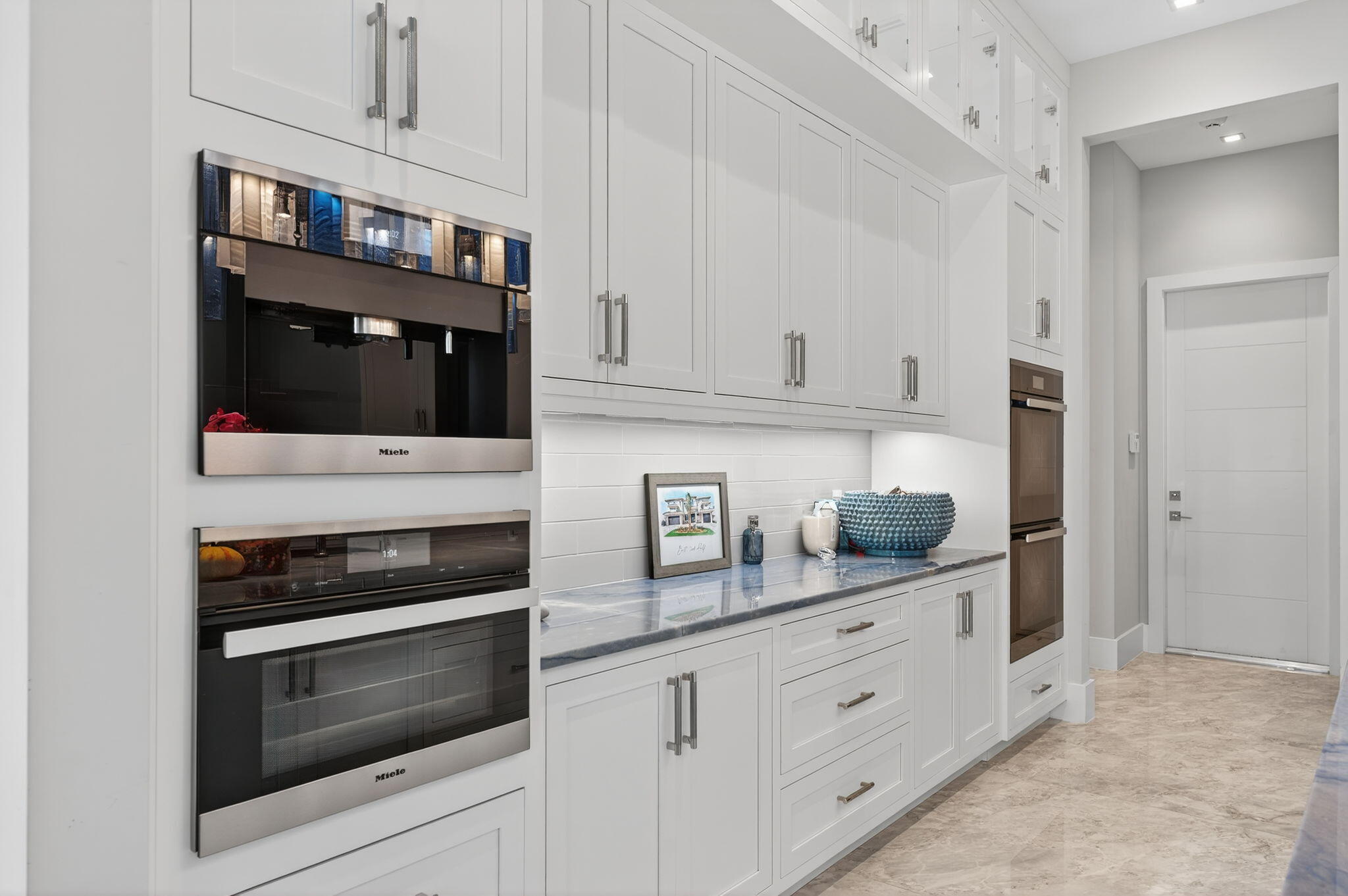 785 Northeast 70th Street Boca Raton, FL 33487 - Photo 22 of 83 a kitchen with white cabinets and stainless steel appliances