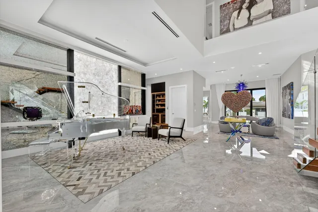 a living room with furniture a large window and a chandelier