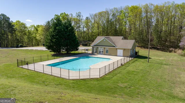 a view of a house with swimming pool and a yard