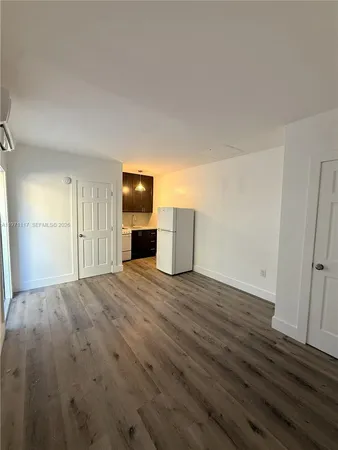a view of empty room with wooden floor and window