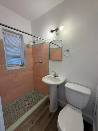 a bathroom with a sink a toilet and shower