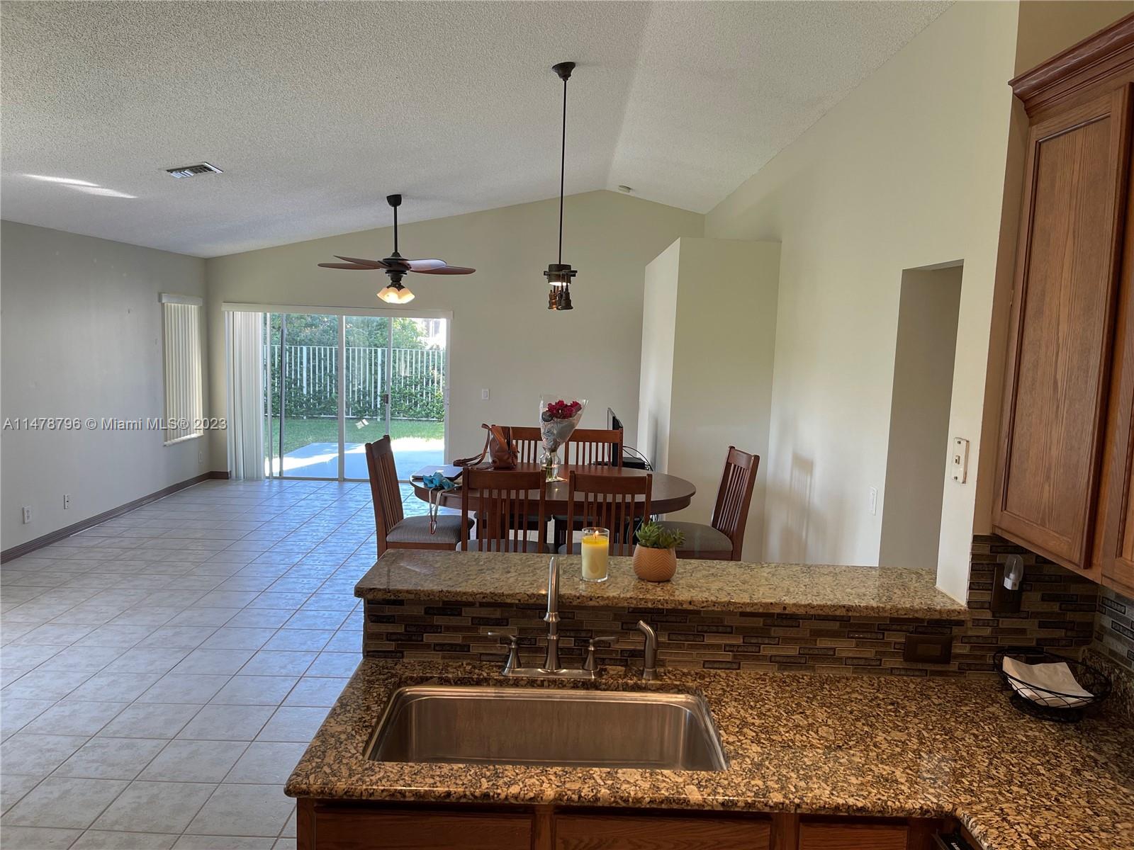 1135 Areca Way Weston, FL 33327 - Photo 13 of 45 a dining room with furniture and a floor to ceiling window