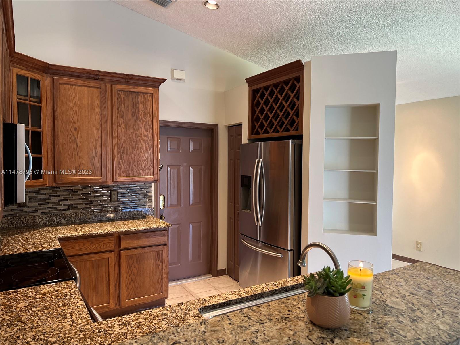 1135 Areca Way Weston, FL 33327 - Photo 15 of 45 a kitchen with a refrigerator and a sink
