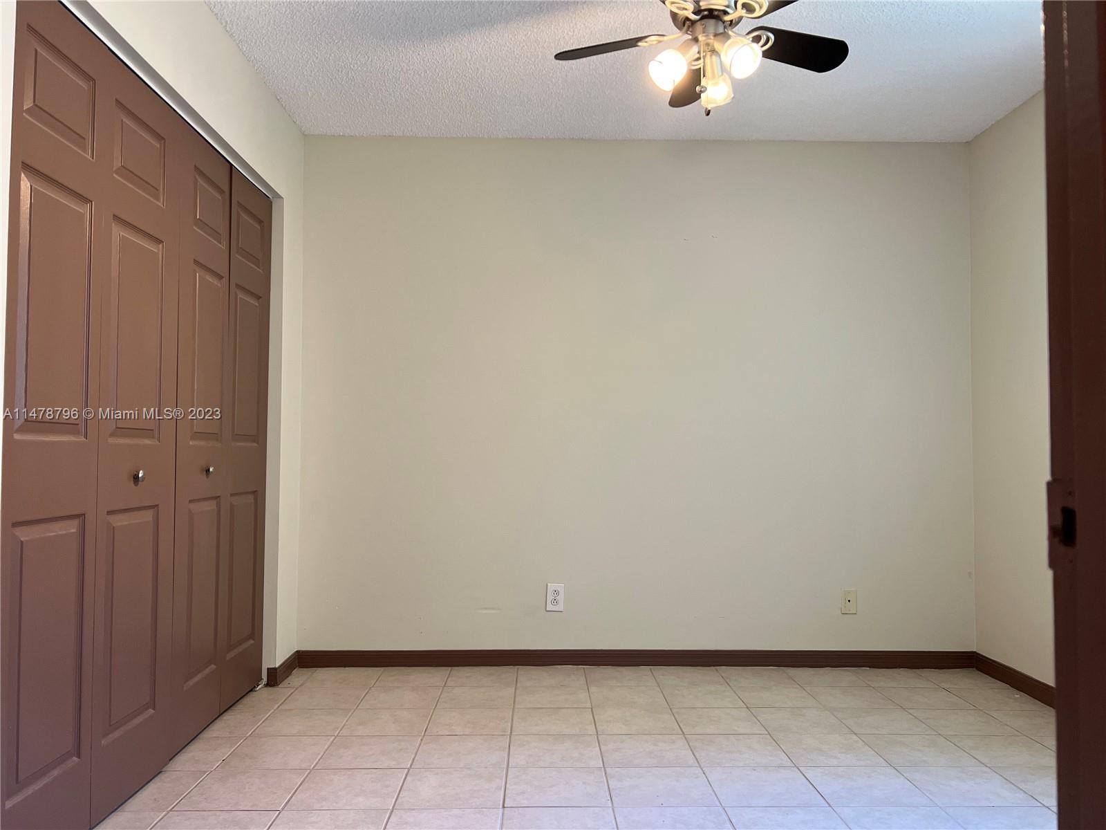 1135 Areca Way Weston, FL 33327 - Photo 16 of 45 an empty room with a chandelier fan
