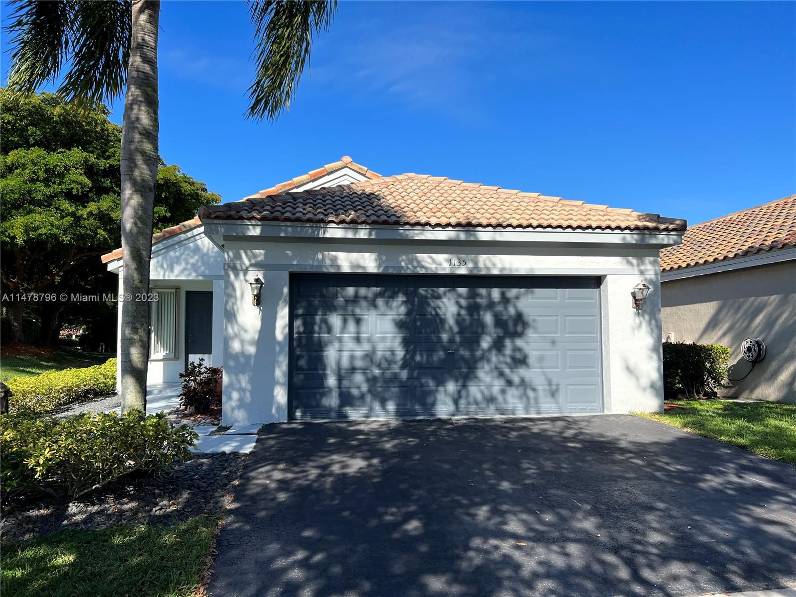 1135 Areca Way Weston, FL 33327 - Photo 2 of 45 a front view of a house with a yard