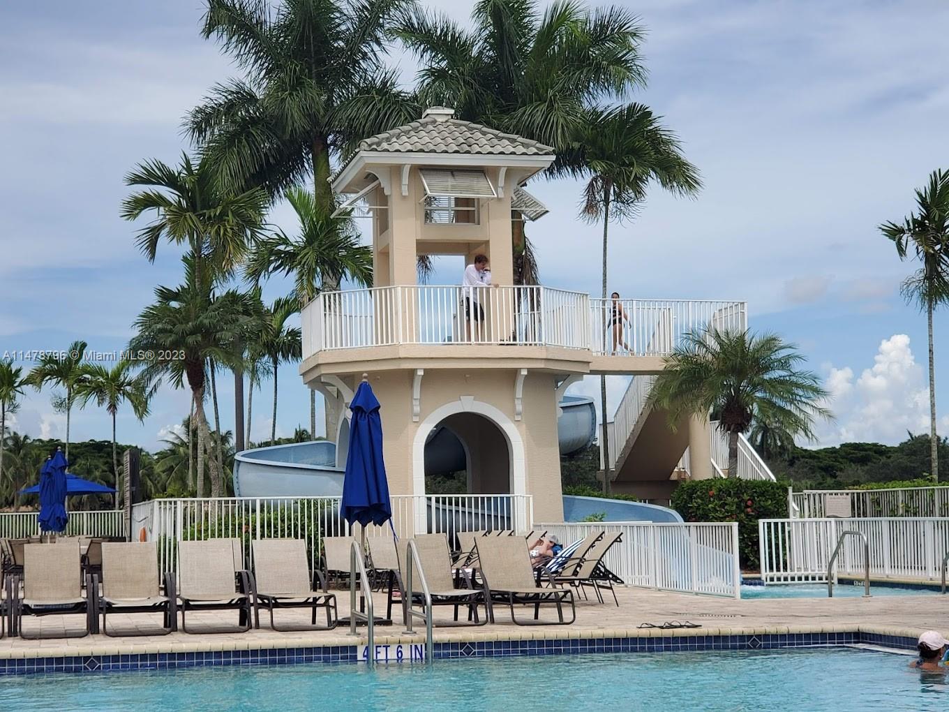 1135 Areca Way Weston, FL 33327 - Photo 33 of 45 a view of a swimming pool with a garden and palm trees