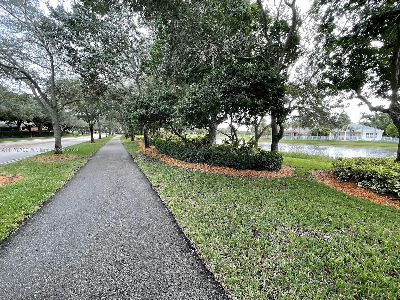 1135 Areca Way Weston, FL 33327 - Photo 41 of 45 a view of a lake with a yard
