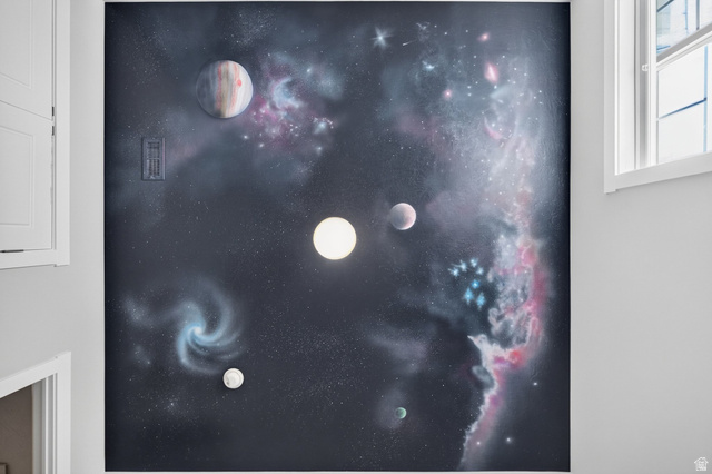 1263 East 1200th South Springville, UT 84663 - Photo 29 of 60 Custom Space-themed, hand painted mural wall featuring celestial bodies and nebulae, with a modern light fixture and white trim window providing natural light