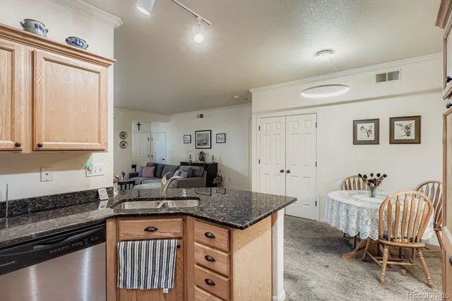 a kitchen with granite countertop a sink and white cabinets