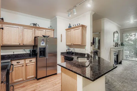 a kitchen with granite countertop a sink stove and refrigerator